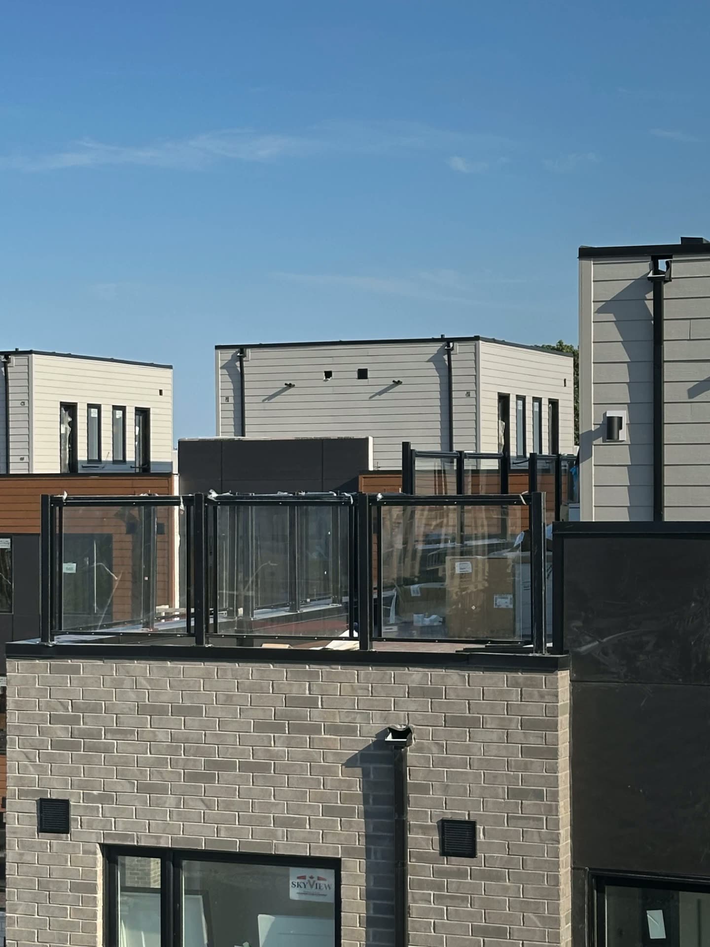 Glass rooftop terrace railing on a modern townhouse