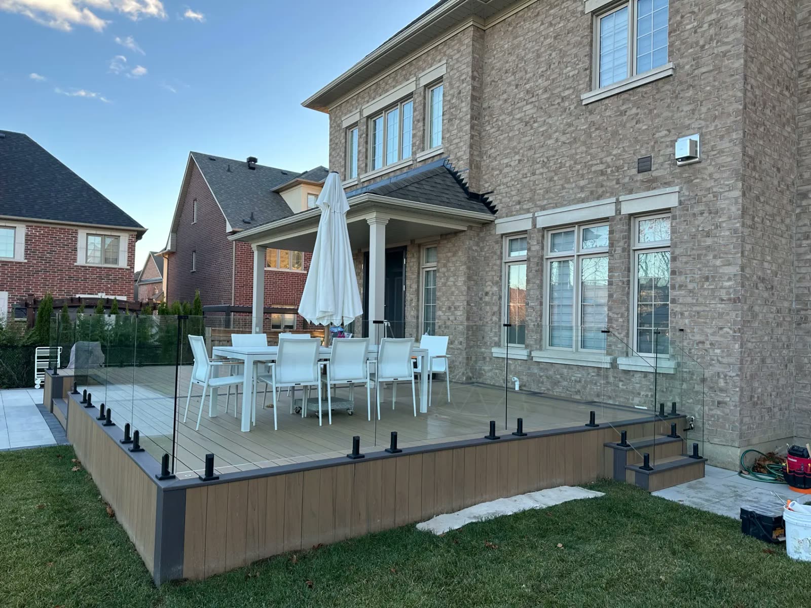 Frameless glass railing around a backyard composite deck