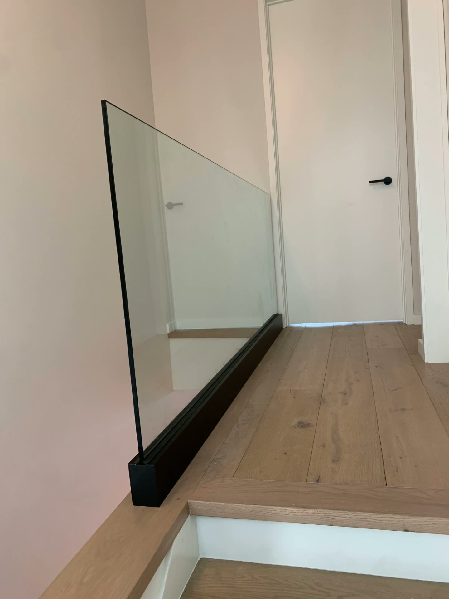 Glass landing railing set in a black base shoe